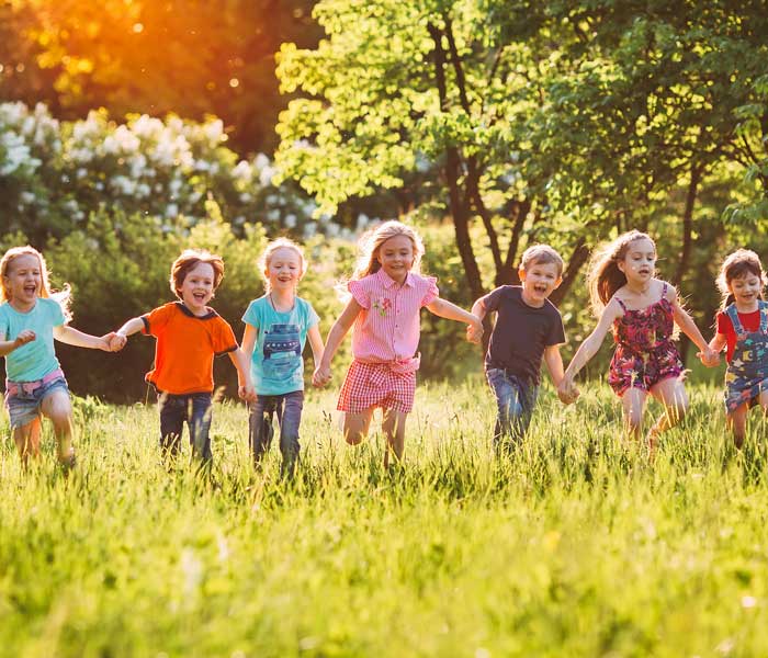 Group of smiling children running in the field